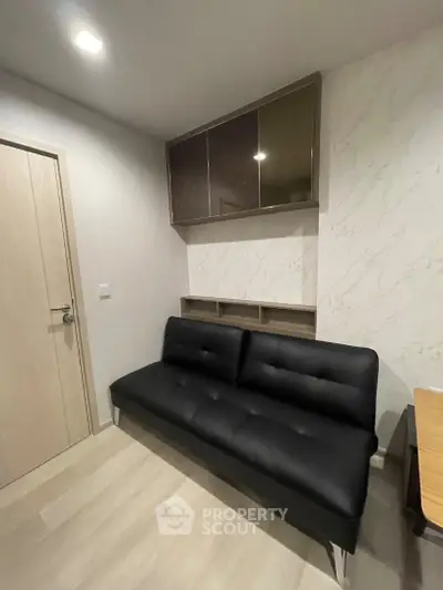 Modern living room with sleek black sofa and stylish wall cabinets