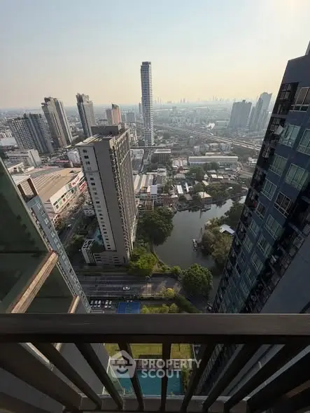 Stunning high-rise cityscape view from a balcony overlooking urban skyline and river.
