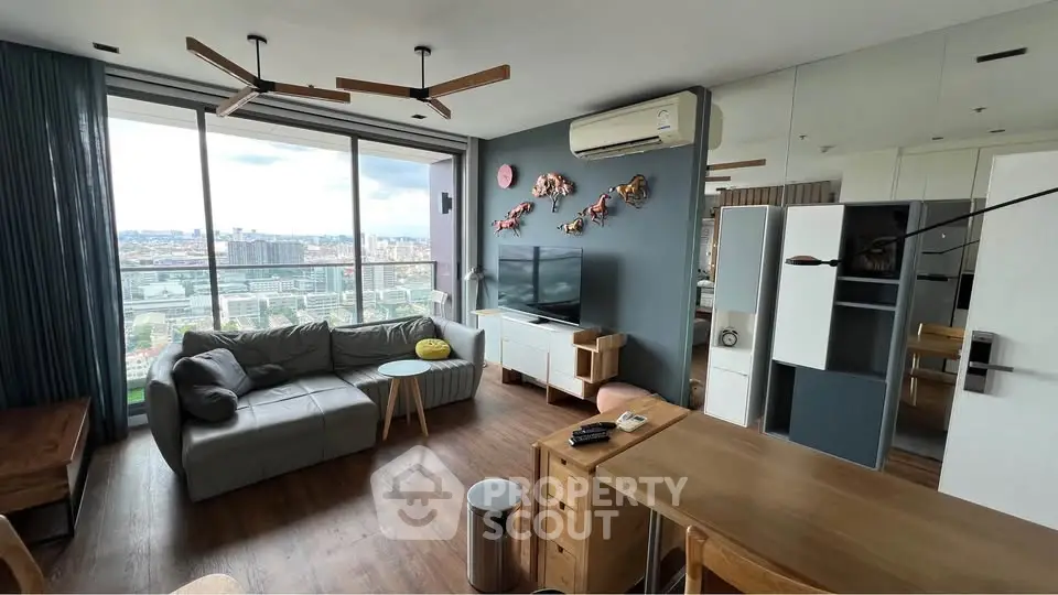 Modern living room with panoramic city view, stylish decor, and cozy seating area.
