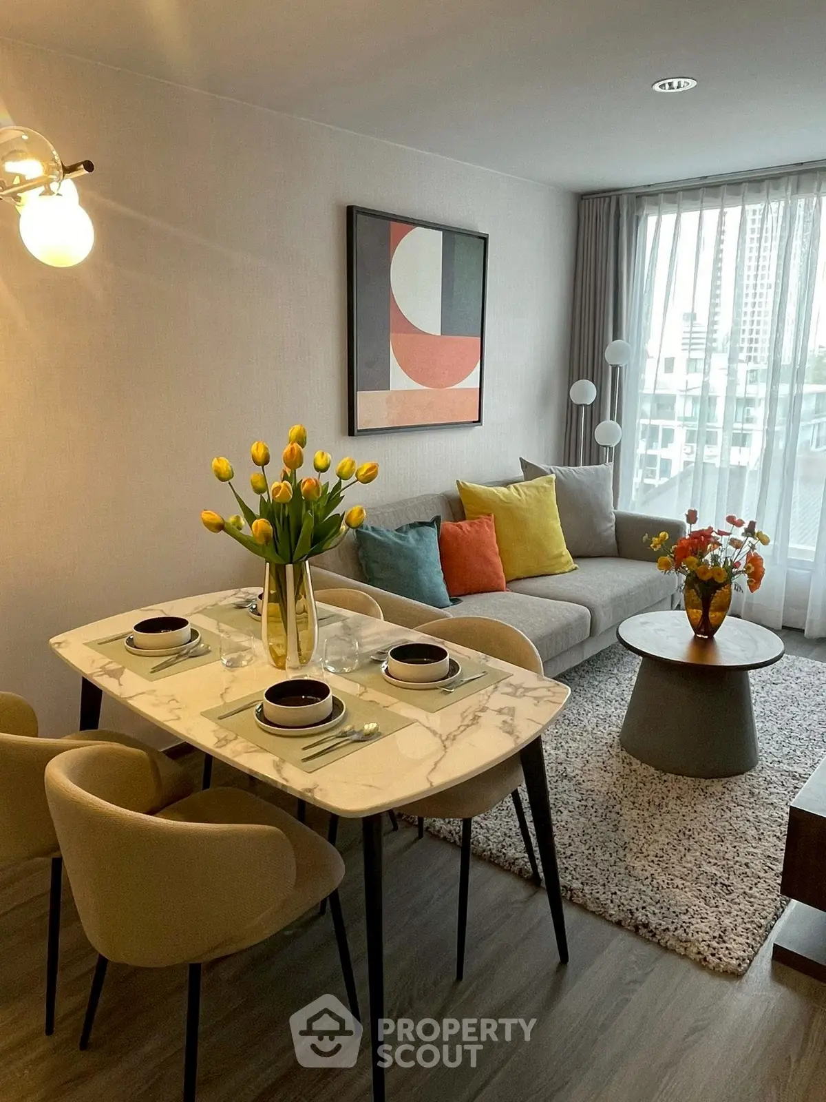 Stylish living room with modern decor and natural light, featuring a cozy seating area and elegant dining setup.