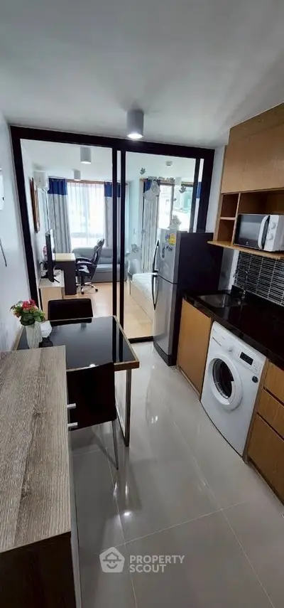 Modern apartment kitchen with washing machine and open layout to living area