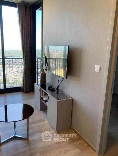 Modern living room with large windows and city view, featuring sleek furniture and stylish decor.