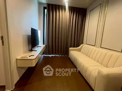 Modern living room with elegant sofa and wall-mounted TV, featuring sleek wooden flooring and stylish curtains.