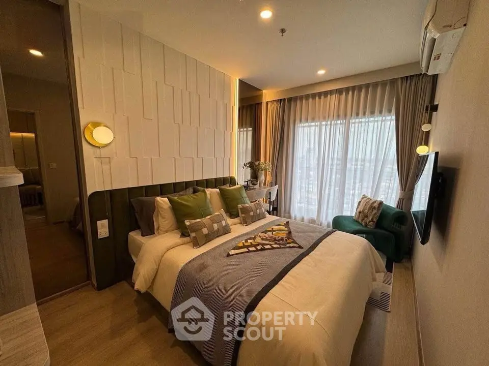 Luxurious bedroom with modern decor and large windows offering natural light and city views.