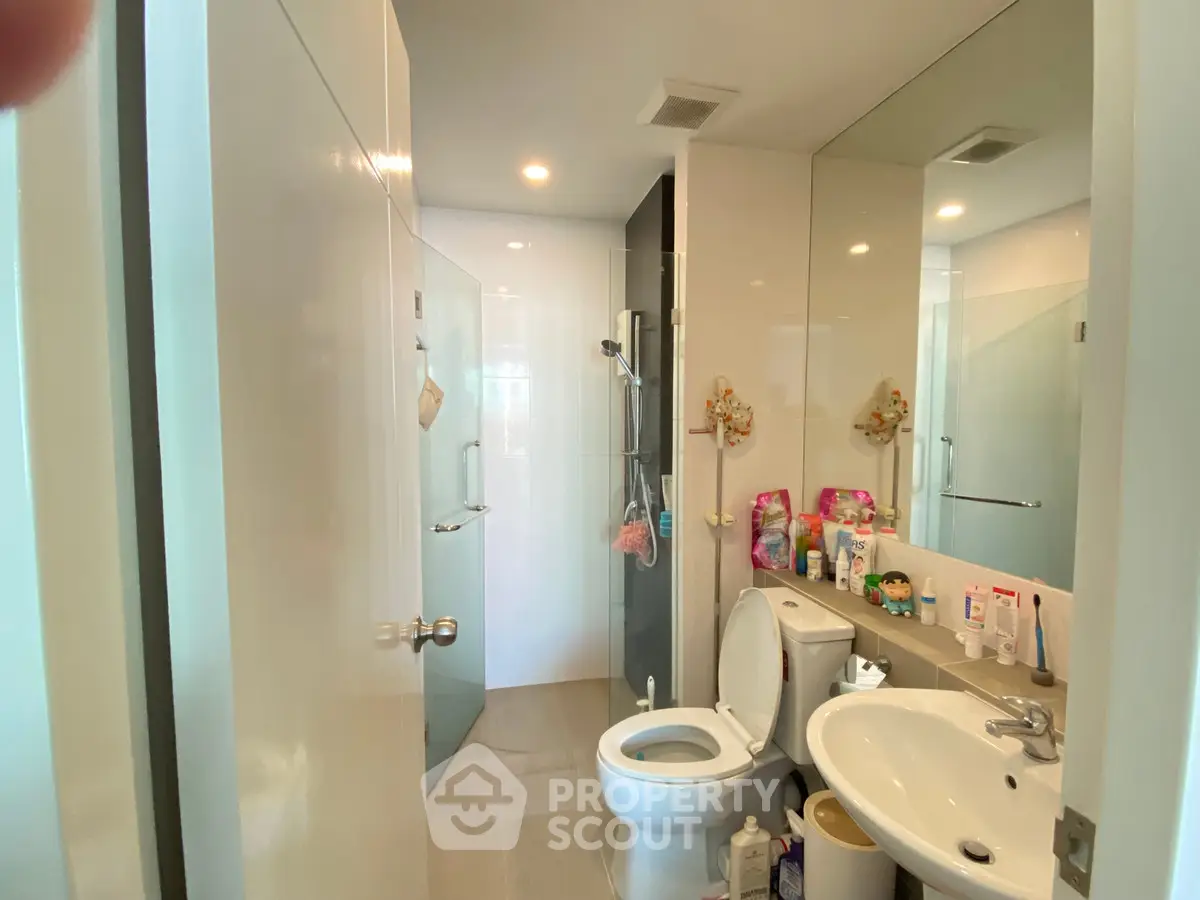 Modern bathroom with glass shower and sleek fixtures in a contemporary home.