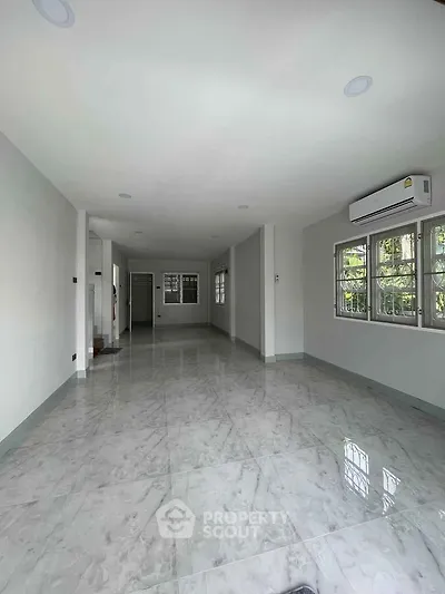 Spacious empty living room with marble flooring and large windows