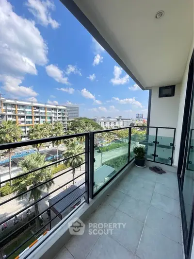 Spacious balcony with city view and modern railing, perfect for relaxation.