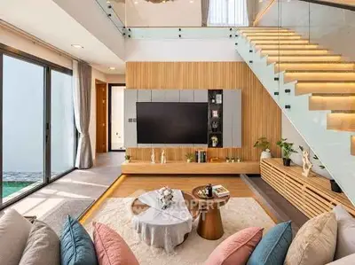 Luxurious modern living room with stylish decor and glass staircase, perfect for elegant entertaining.