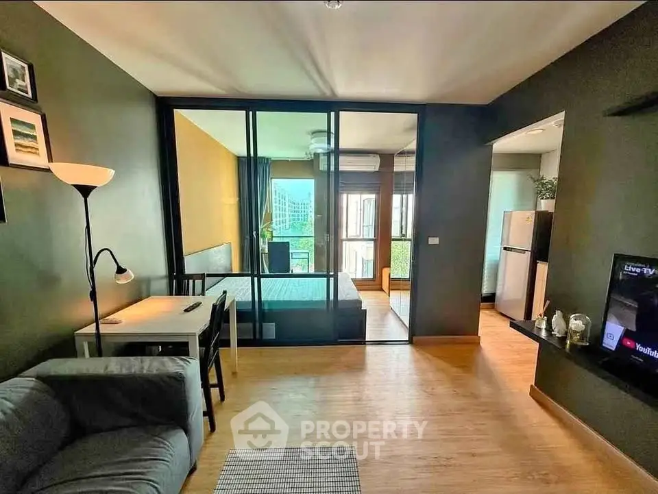 Modern living room with glass partition, cozy sofa, and stylish decor