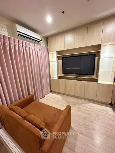 Cozy living room with modern TV unit and plush sofa, perfect for relaxation.