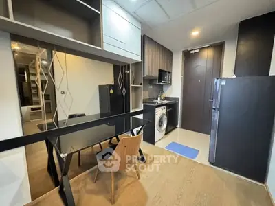 Modern compact kitchen with sleek appliances and stylish dining area