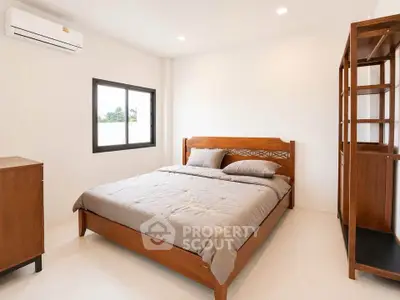 Spacious bedroom with wooden furniture and natural light