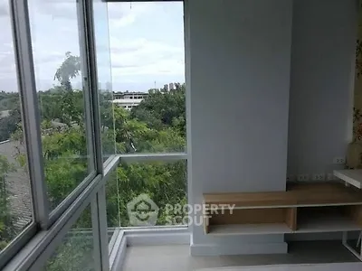 Bright corner unit with large windows offering lush green views, perfect for a serene living space.