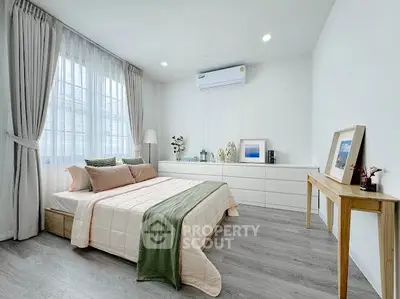 Spacious and modern bedroom with elegant decor and natural light.