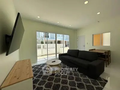 Modern living room with sleek furniture and large windows offering natural light