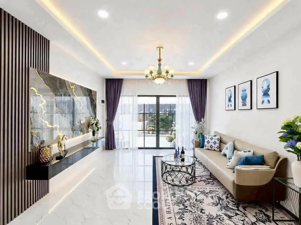 Luxurious modern living room with elegant decor and spacious layout, featuring a stylish chandelier and large windows.