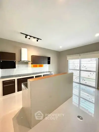 Modern kitchen with sleek cabinets and large window for natural light