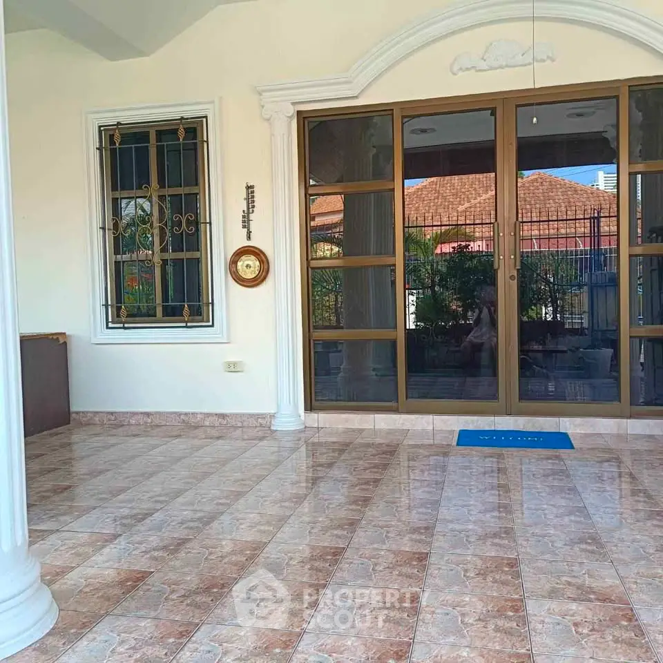 Charming home entrance with elegant tiled flooring and classic columns