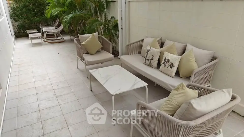 Charming outdoor patio with cozy seating and lush greenery, perfect for relaxation and entertaining.