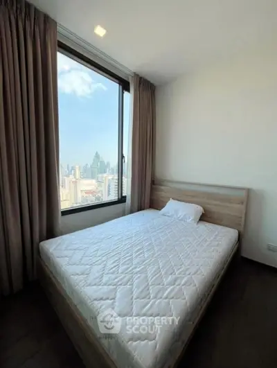 Modern bedroom with city view, featuring a large window and minimalist decor.