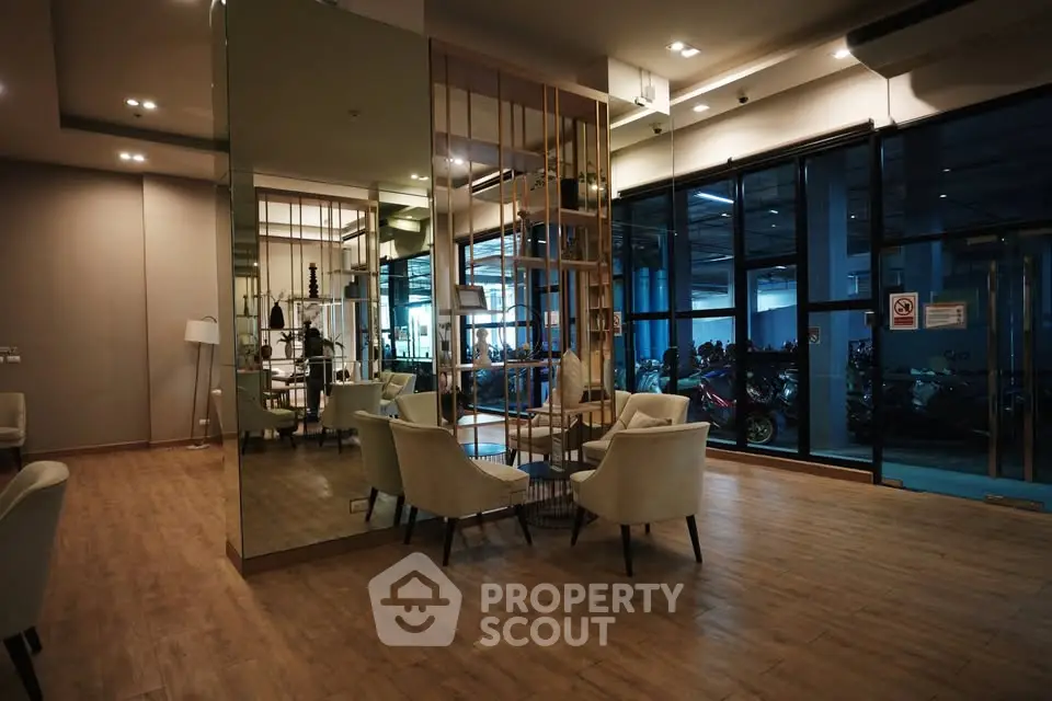 Modern lobby with elegant seating and mirrored walls in a stylish building entrance.