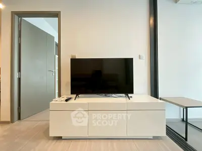 Modern living room with sleek TV stand and flat-screen TV, minimalist design.