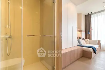 Modern bedroom with ensuite bathroom featuring sleek shower and cozy decor.