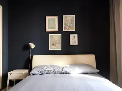 Cozy bedroom with modern decor and stylish wall art in a serene setting.