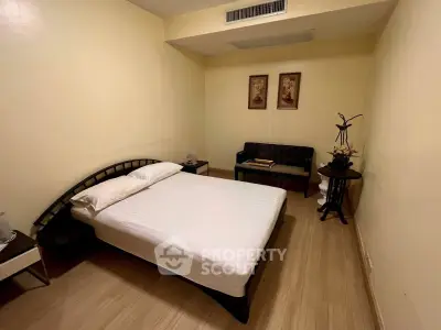 Cozy bedroom with minimalist decor and wooden flooring, perfect for relaxation.