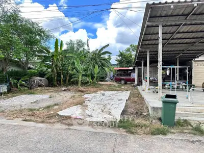 Spacious outdoor area with potential for development, featuring a covered patio and lush greenery.