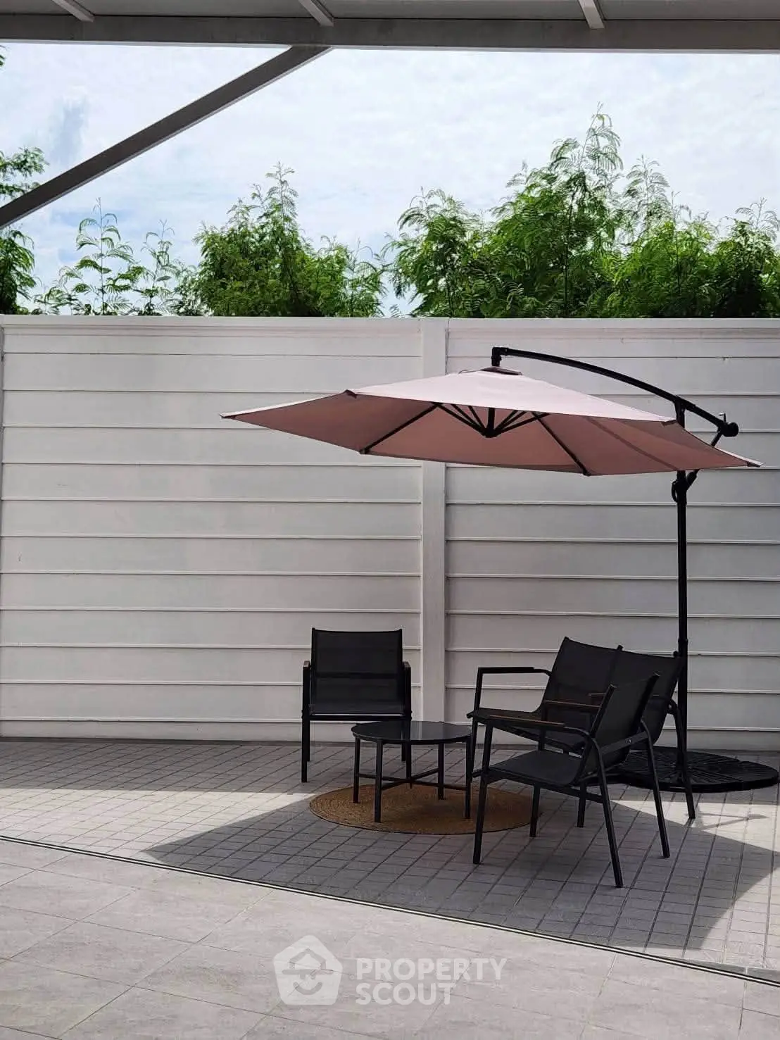 Modern outdoor patio with stylish furniture and umbrella, perfect for relaxation and entertaining.
