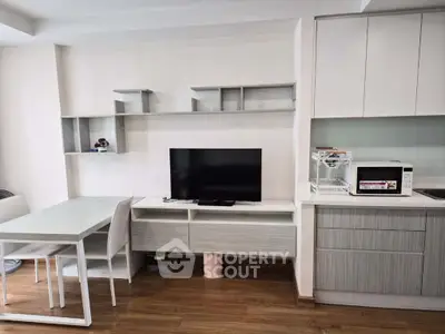 Modern living room with sleek furniture and integrated kitchen area, perfect for urban living.