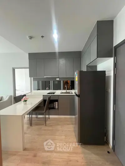 Modern kitchen with sleek cabinetry and open layout in contemporary apartment.