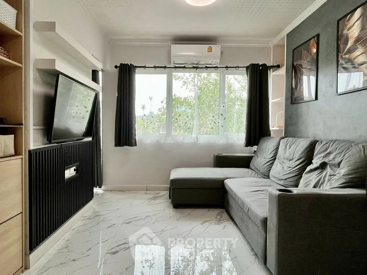 Modern living room with sleek design, featuring a large window, stylish sofa, and wall-mounted TV for ultimate comfort.