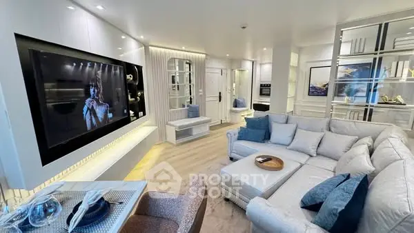 Luxurious modern living room with large sectional sofa and wall-mounted TV, perfect for entertaining.