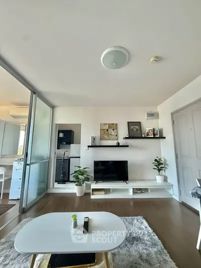 Modern living room with sleek decor and open layout, featuring a TV and stylish shelving.