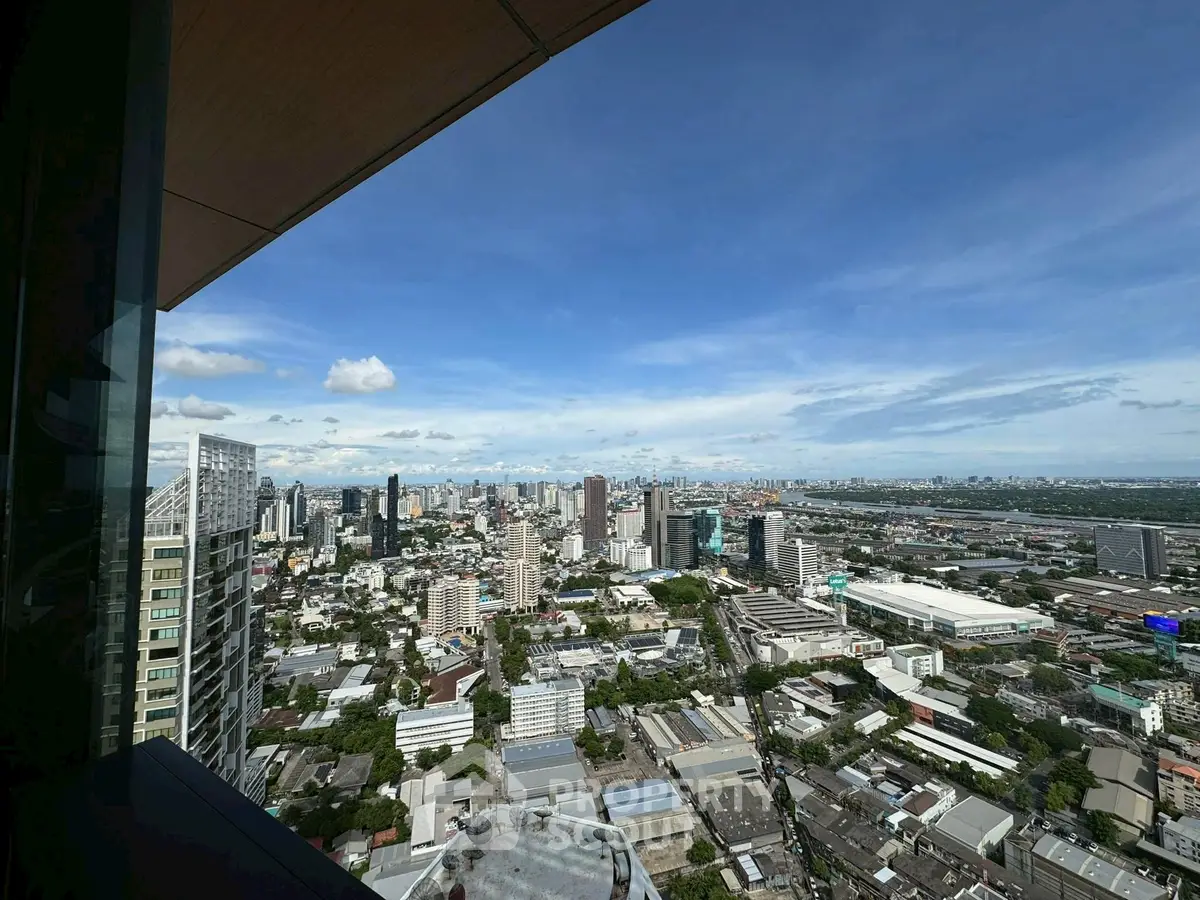 Stunning cityscape view from high-rise building showcasing urban skyline and clear blue sky.