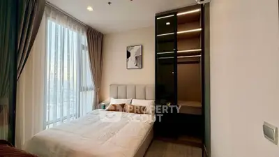 Modern bedroom with large window and stylish decor in a high-rise apartment.