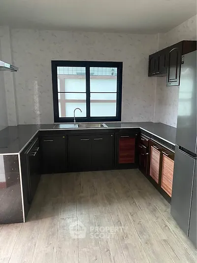 Modern kitchen with sleek black cabinetry and stainless steel appliances