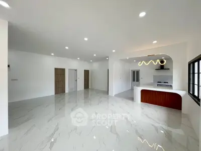 Spacious modern living room with sleek marble flooring and stylish open kitchen layout.