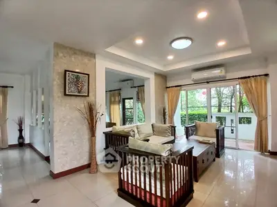 Spacious living room with elegant decor and large windows offering garden views.