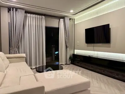 Modern living room with sleek design, featuring a large sofa, wall-mounted TV, and elegant curtains.