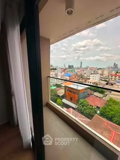 Stunning cityscape view from a modern apartment balcony with glass railing.