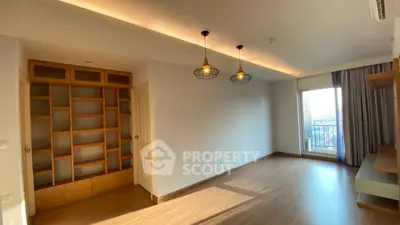 Spacious living room with modern lighting and large window balcony access
