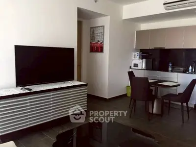 Modern living room with sleek TV and stylish dining area in open layout.