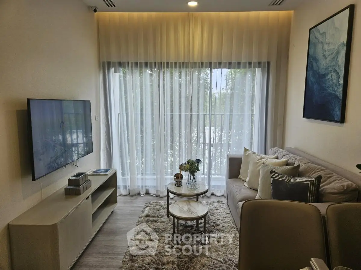 Modern living room with cozy sofa, wall-mounted TV, and elegant decor
