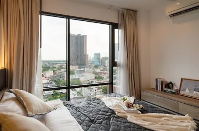 Cozy bedroom with city view, featuring modern decor and large window.
