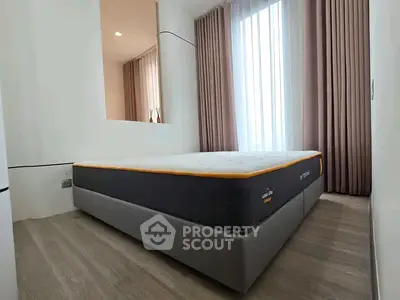 Modern bedroom with stylish bed and floor-to-ceiling curtains in a bright apartment.