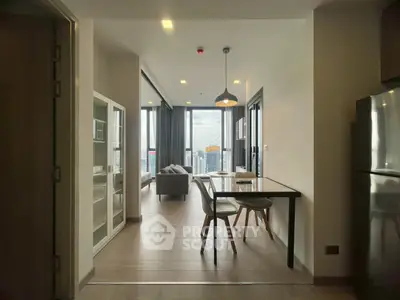 Modern open-plan living and dining area with city view, featuring sleek furniture and large windows.