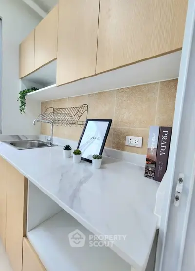 Modern kitchen with sleek cabinetry and marble countertop, featuring a stylish open layout and elegant decor.